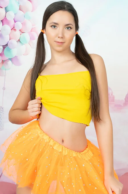 Pig-tailed brunette girl takes off top and tutu